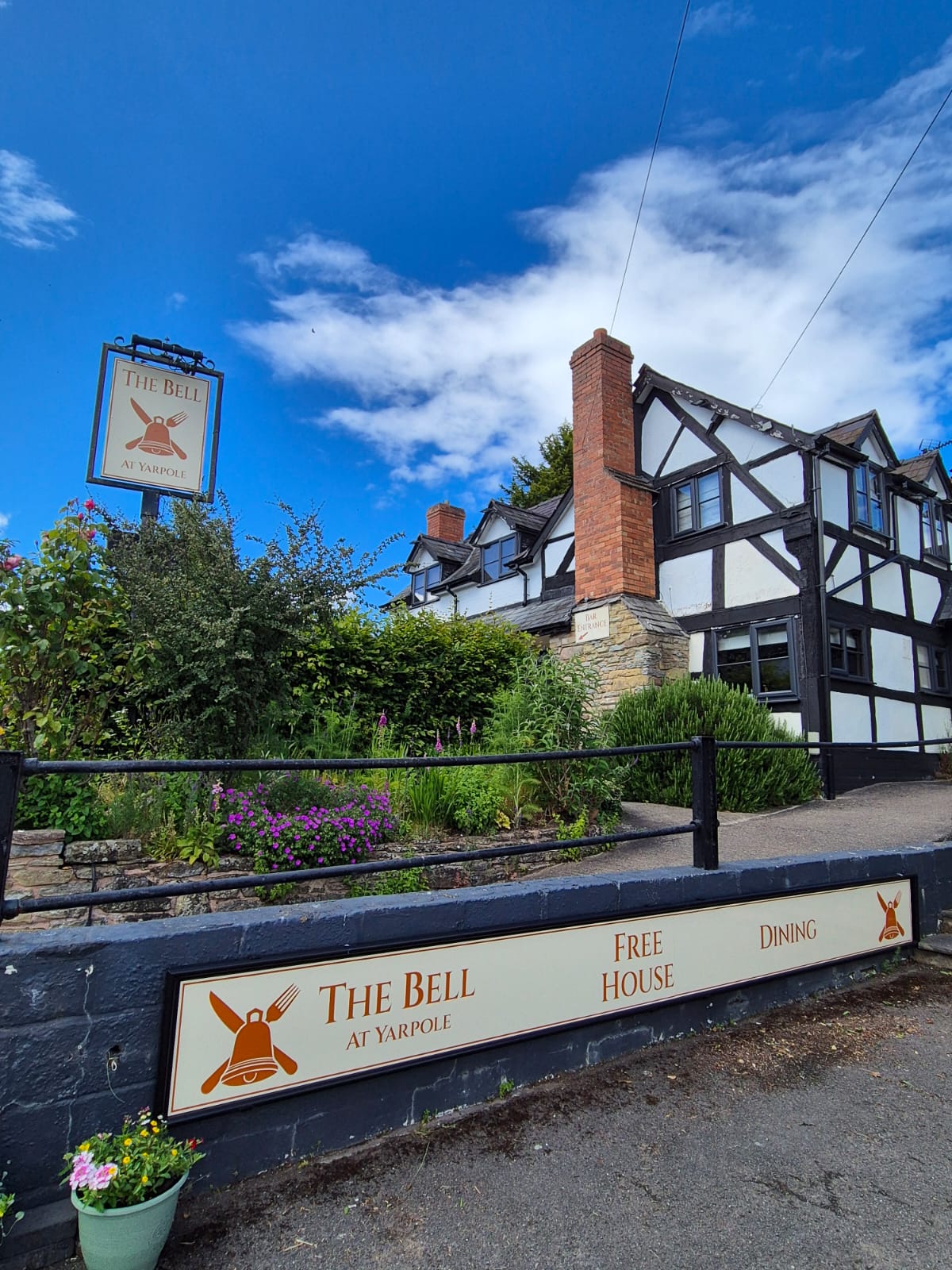 The Bell at Yarpole, a black and white timber-framed country pub, seen from the lane